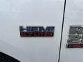 A chrome badge displaying the word HEMI and the text 5.7 LITER in red on the side of a white 2015 RAM 2500 truck