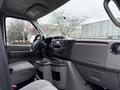 Interior view of a 2024 Ford E-450 showing the dashboard center console and seating area with gray upholstery