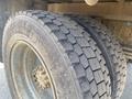 Close-up view of a heavy-duty truck tire with deep treads showing wear and dirt on a 1996 GMC Top Kick