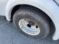 A close-up of a tire from a 2013 Chevrolet Express showing visible wear and rust on the rim with a rugged tread pattern