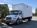 A white 2011 Freightliner M2 106 box truck with a large cargo area and cab, featuring multiple orange lights on the roof and a grille with horizontal bars