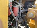 Close-up of the engine compartment of a 2010 Vermeer Corporation BC1200XL showing red filters and various cables and components