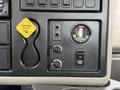 The dashboard of a 2014 International 7500 featuring a parking brake lever a filter monitor and two control knobs