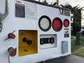 A close-up of the control panel on a 2013 International Durastar 4300 featuring warning lights switches and labels