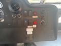 Control panel of a 2012 Ford E-450 featuring various switches and gauges including a speedometer and indicators for seatbelt and door alerts