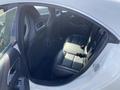 Interior view of a 2014 Mercedes-Benz CLA-Class showing black leather rear seats with headrests and seat belts
