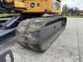 A close-up of the track of a yellow 2017 John Deere 50G excavator showing textured rubber and metal components