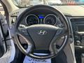 Interior view of a 2015 Hyundai Sonata showing the steering wheel and dashboard with speedometer and multimedia controls