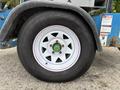 Close-up of a tire on a 2016 Genie TZ-34/20 with a white rim featuring a green center hub and black treaded rubber surface