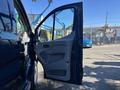 A 2016 Ford Transit 150 with an open driver's side door showcasing the interior handle and door panel