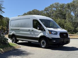 A 2022 Ford Transit van in white with a sleek design and large cargo area features and a modern front grille