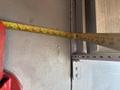 A tape measure extends across a wall next to a 2011 Workhorse W62 truck component showing measurements along its length