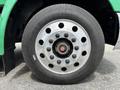 Close-up of a wheel on a 2013 Kenworth T370 featuring a silver rim with multiple circular holes and a black tire with visible tread pattern