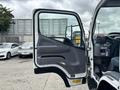 The image shows the open door of a 2015 Mitsubishi Fuso FE160 revealing the cabin interior with controls and seating visible