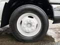 Close-up of a white wheel and tire from a 2017 Ford E450 showcasing the tire tread and bolt pattern