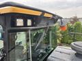 A 2012 Caterpillar 980 with a prominent yellow and gray exterior featuring a large cab, windshield wipers, and overhead lights