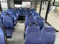 An interior view of a 2020 Chevrolet Express showing rows of blue upholstered seats arranged in a spacious layout