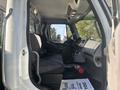 Interior view of a 2022 Freightliner M2 106 featuring a driver’s seat a dashboard with controls and displays alongside a passenger seat