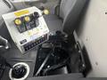Interior view of a 2016 Freightliner 108SD displaying the control panel with levers and buttons along with the driver's seat and gear shift