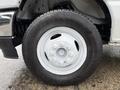 Close-up of a white wheel from a 2022 Ford Econoline featuring a silver hubcap and black tire with visible tread marks