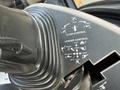Close-up of the control panel of a 2005 Case 570 featuring buttons and diagrams for clam control and loader control functions