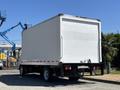 A white 2022 Isuzu NQR box truck with a plain cargo area and no visible branding parked at an angle