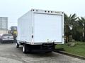 A 2019 Ford Econoline box truck with a white exterior and rear access door parked on a driveway