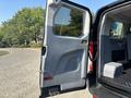 The image shows the open side door of a 2016 Ford Transit 150 with a gray interior and a visible handle and latch system