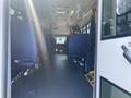 Interior view of a 2020 Chevrolet Express with blue fabric seats arranged in rows and a clear aisle leading to the front of the vehicle
