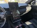 A 2023 Fisker Ocean interior featuring a large vertical touchscreen display with various digital controls and information tools on the center console