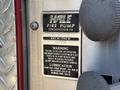 A metal label on a fire truck featuring the Hale Fire Pump logo and specifications including model number serial number and maintenance warnings