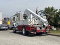 A 2012 International 7300 Workstar truck with a red and white color scheme features an elevated boom and basket mounted on the back for utility work