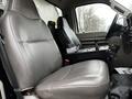 Interior of a 2009 Ford F-550 showing two gray seats with a central console and gear shifter between them