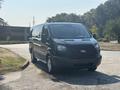 A black 2016 Ford Transit 150 van parked on a road with a prominent front view showing its distinctive grille and headlights