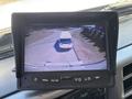 A monitor displaying a rear view of a 2020 Hino 338 truck backing up in a parking area