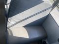 A gray vinyl bench seat from a 2006 Thomas Saf-T-Liner HDX school bus with a slight curvature and a textured surface