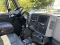 Interior of a 2008 International DuraStar showing the steering wheel dashboard gear shift and various control panels