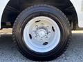 Close-up of a white-painted wheel and tire of a 2019 Freightliner MT45 featuring a multi-lug hub and all-weather tread design