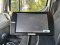 A digital display screen mounted inside a 2013 Freightliner 114SD truck cabin with a control stick beside it