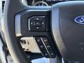 Close-up of the steering wheel controls of a 2020 Ford F-350 SD featuring buttons for navigation and cruise control settings