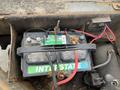 A close-up of two deep cycle batteries secured with a strap showing red and black cables connected to them labeled INTERSTATE