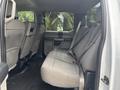 Interior view of the back seat of a 2017 Ford F-150 with gray fabric upholstery and seat belts attached