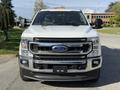 A 2021 Ford F-250 Super Duty pickup truck shown from the front with a white exterior and chrome grille featuring the Ford emblem