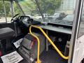 Interior view of a 2018 Ford Econoline showing the driver's seat steering wheel and dashboard with a yellow handrail alongside the seating area
