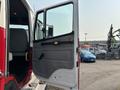 The image shows the open driver's door of a 1999 Freightliner FL80 truck with a gray interior and a black handle