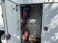 An open compartment of a 2006 International 4300 displaying two reels with red hoses mounted inside the metal enclosure
