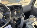 Interior dashboard of a 2006 Freightliner M2 106 with various controls and a stereo system visible along with a gear shift and cup holders