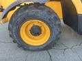 A close-up of a JCB 510-56 Loadall tire showcasing the tread pattern and wheel rim in orange and black colors