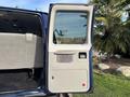 The image shows the open side door of a 2013 Ford E-350 Super Duty van displaying a gray interior panel with a handle and window