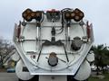 The rear view of a 2013 International Workstar 7500 featuring lights and equipment mounted on a flatbed area with valves and chains visible
